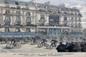 Eine Gruppe von Radfahrern fährt eine Straße vor einem Gebäude entlang, mit wehenden Fahnen im Hintergrund unter einem klaren blauen Himmel; Text unten lautet "Le Départ de la Course Paris-Brest".