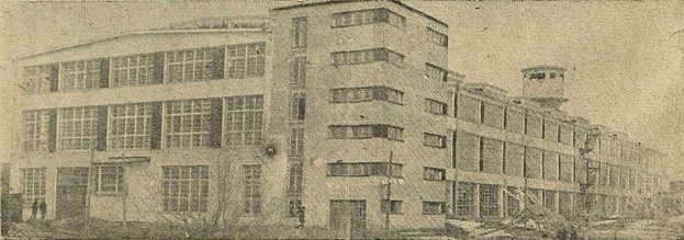 Schwarz-weiß-Foto eines großen Gebäudes mit vielen Fenstern, beschriftet mit "New York Post Office", umgeben von Bäumen unter einem klaren Himmel.