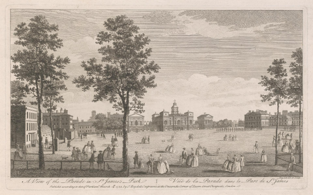 Eine Gruppe von Menschen, die während eines Umzugs in St. James Park steht und sitzt, mit Bäumen und Gebäuden im Hintergrund unter einem bewölkten Himmel.