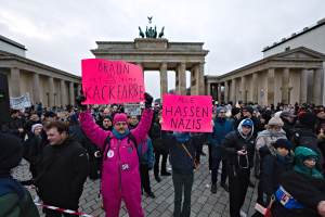 Eine Gruppe von Menschen protestiert vor dem Reichstagsgebäude in Berlin und hält Schilder gegen die Anti-Nazi-Bewegung der deutschen Regierung.