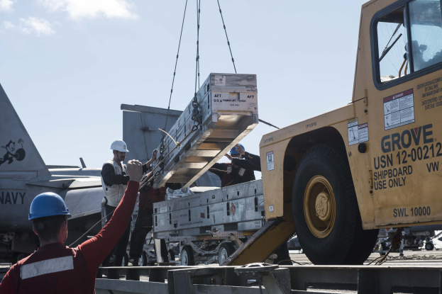 Ein Schwarz-Weiß-Foto eines großen, vierrädrigen Lkw mit einem Kran auf der Ladefläche, der als erstes Schwerlastfahrzeug gilt, mit einem Anhänger.