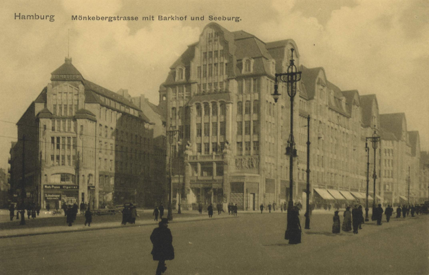 Altes Schwarz-Weiß-Foto von Menschen, die eine Straße in Hamburg, Deutschland, entlanggehen, mit Gebäuden, Straßenlaternen, Straßenlaternen und Kraftfahrzeugen, die entlang der Straße aufgereiht sind, unter einem bewölkten Himmel.