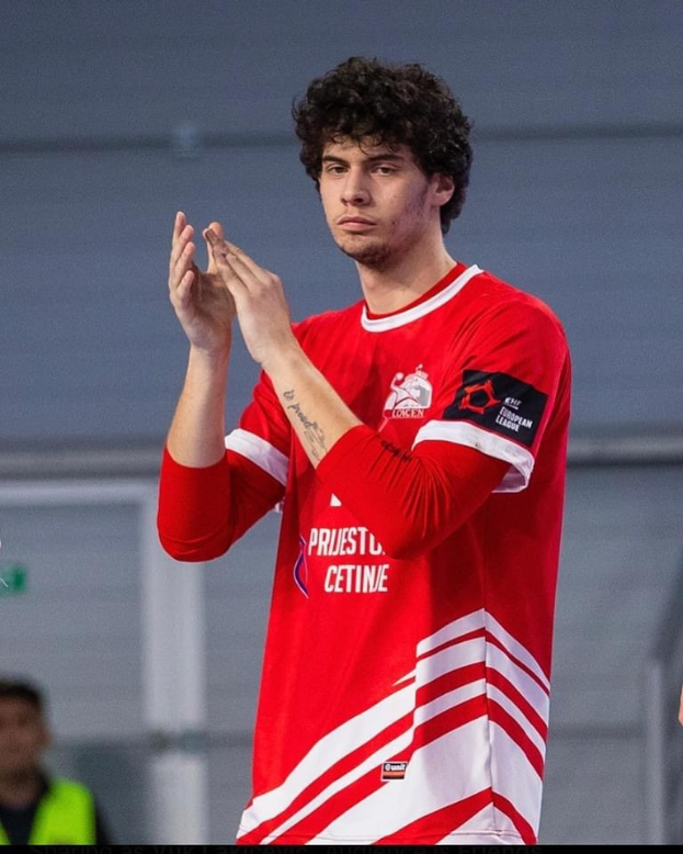 Ein Mann in rot-weißem T-Shirt klatscht im Vordergrund mit einer anderen Person und einer Wand im Hintergrund, mit dem Text "Copenhagen Futsal Club - Foto 1" unten.